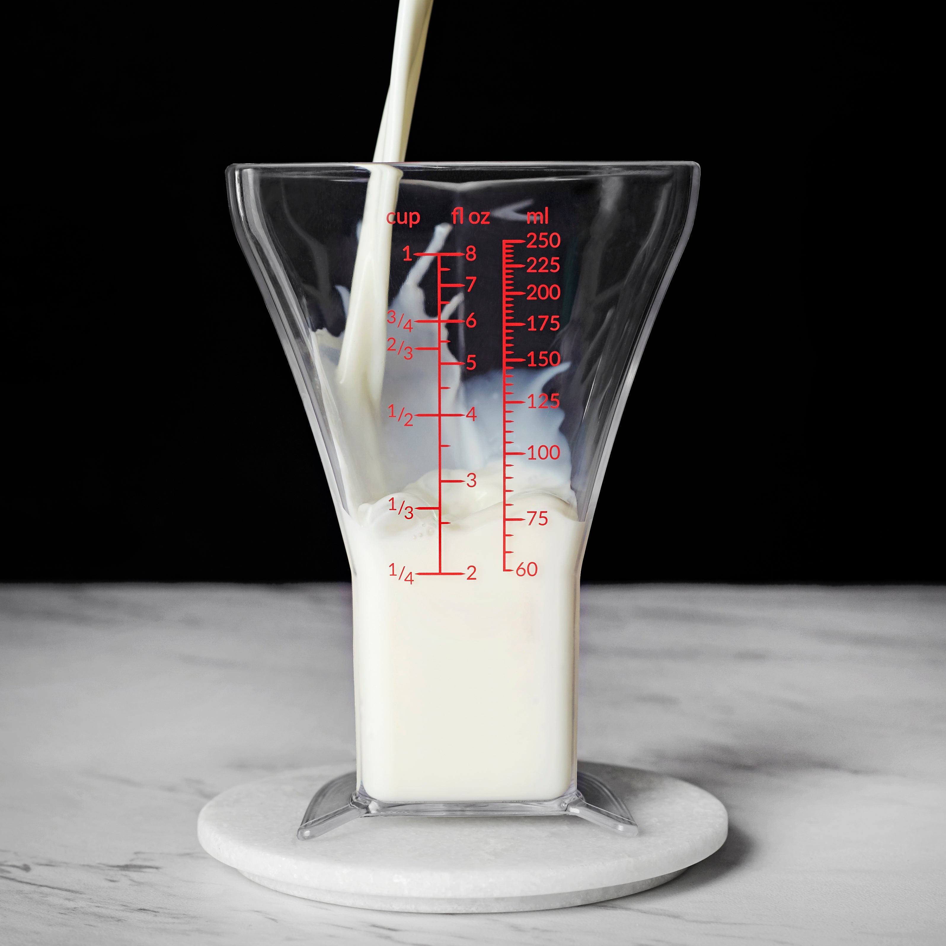 a-stream-of-milk-pours-into-triangle-shaped-measuring-glass.jpg